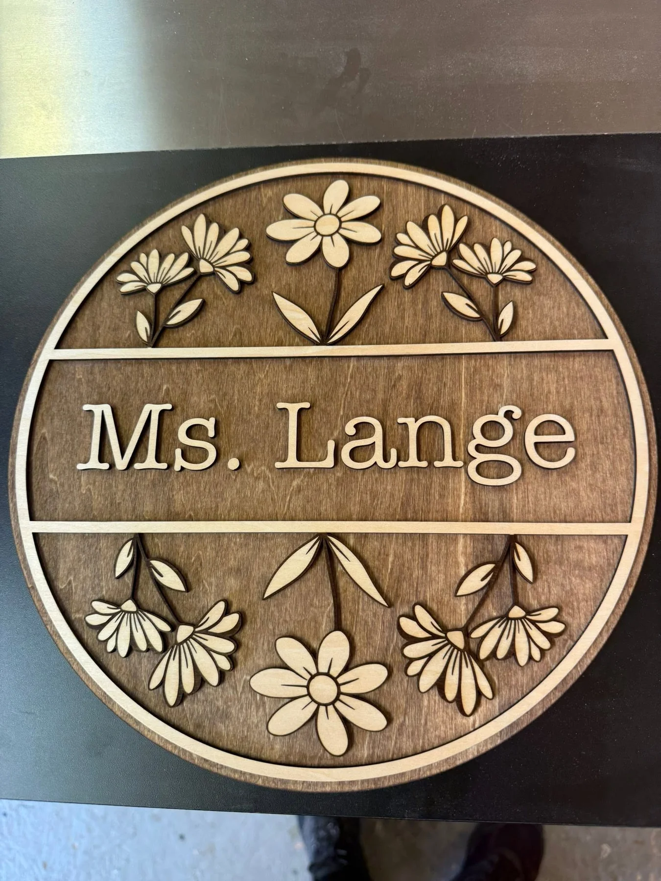 Round layered wooden name sign with delicately detailed flowers