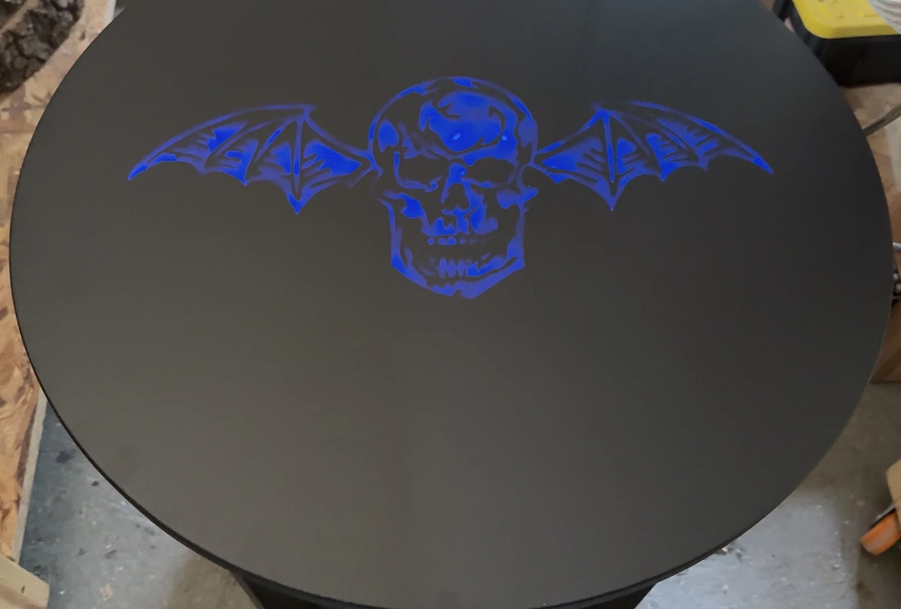 Close view of an electric-blue, hand-finished graphic on the black tabletop